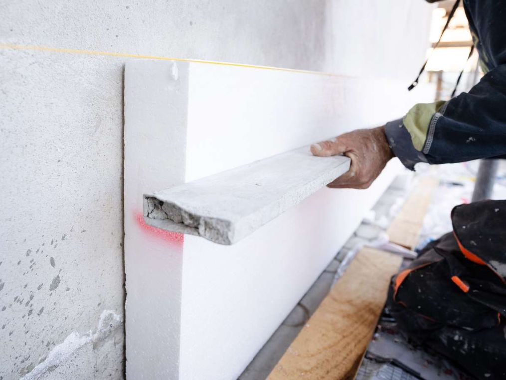 Trabajador colocando Aislamiento térmico en la pared de una vivienda